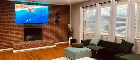 TV connectée, cheminée, livres, médiathèque
