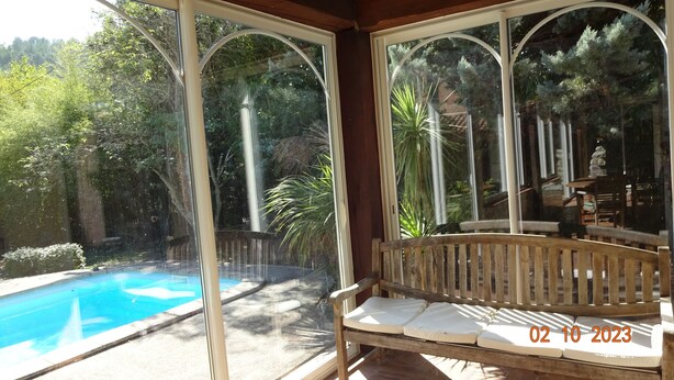 A covered outdoor seating area with a pool and garden view. - Spacious villa in theAude close to the sea, mountains, history and vineyards! (Montazels)