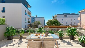 A rooftop terrace with a table set for two, surrounded by potted plants, under a clear blue sky. - Sun Spalato Flower (Split)