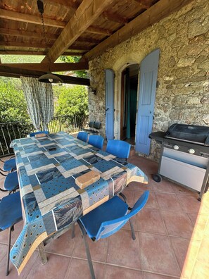Enjoy al fresco dining on the patio, surrounded by lush greenery and a barbecue grill.