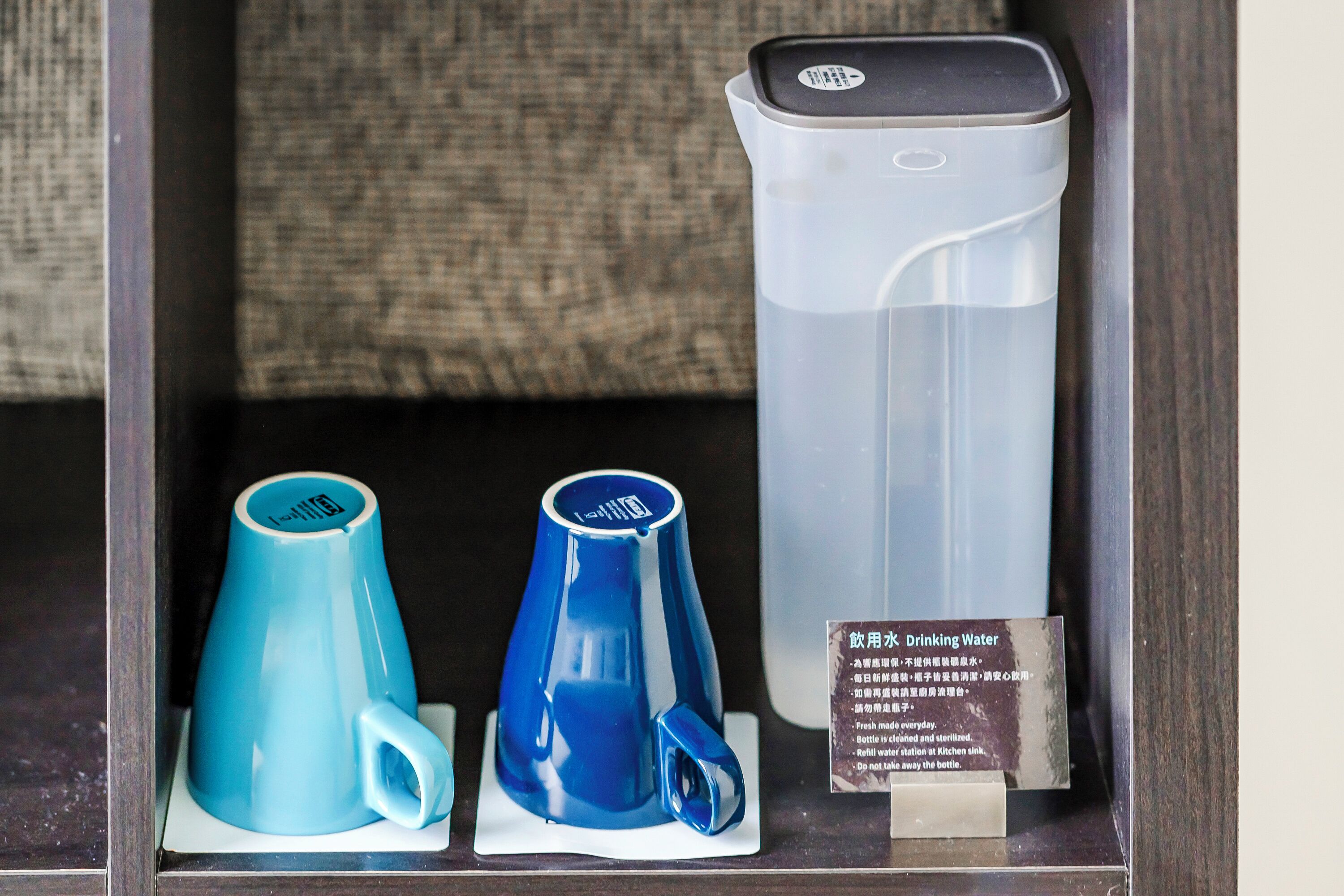 Presentación de vasos de agua y dispensador en un entorno de hotel.