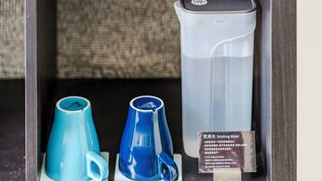 Presentación de vasos de agua y dispensador en un entorno de hotel.