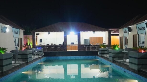 Une piscine avec des chaises longues et un espace bar.