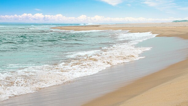 A beach with waves gently lapping onto the shore. - Azura Golf Resort & Spa (Mahavelona)