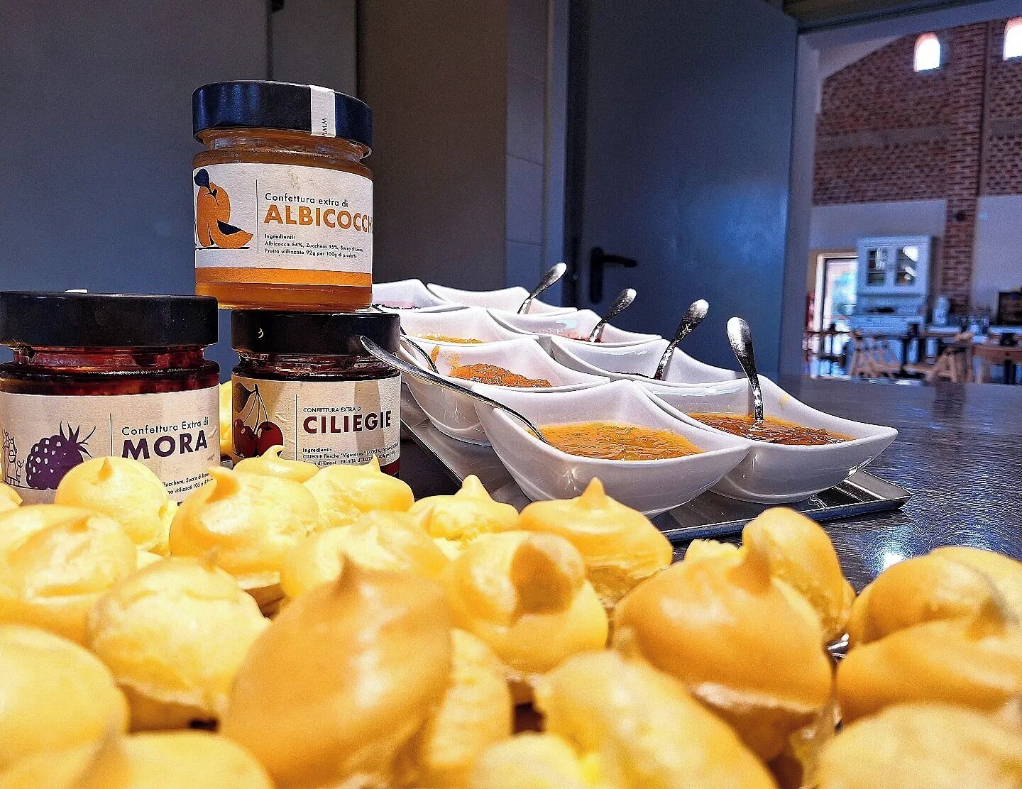 Exposição de alimentos com potes de vinagre balsâmico extra, azeite extra e mel de cereja, além de várias tigelas brancas com diferentes molhos.