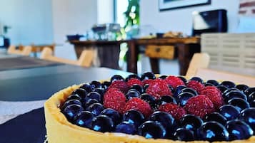 A dessert with berries on a plate in a room with a desk and a window.