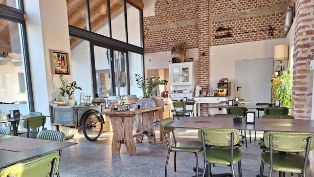 A spacious dining area with high ceilings, exposed brick walls, and large windows. - Cascina Mora Bassa (Vigevano)
