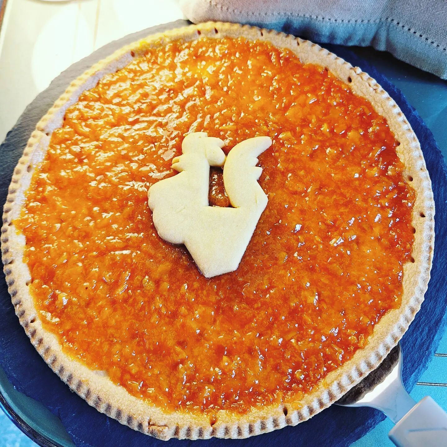 A pie with a decorative topper on a blue plate.