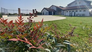 A building with a clear sky and a fenced area in the foreground. - Cascina Mora Bassa (Vigevano)
