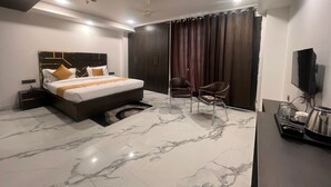 A modern hotel room with a large bed, a desk, a chair, and a TV. - Hotel Grey Sky  (New Delhi)