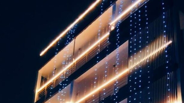 A multi-story hotel with balconies and a prominent sign. - Hotel Grey Sky  (New Delhi)
