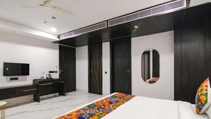 A modern hotel room with a large bed, a desk, a television, and a wardrobe. - Hotel Grey Sky  (New Delhi)
