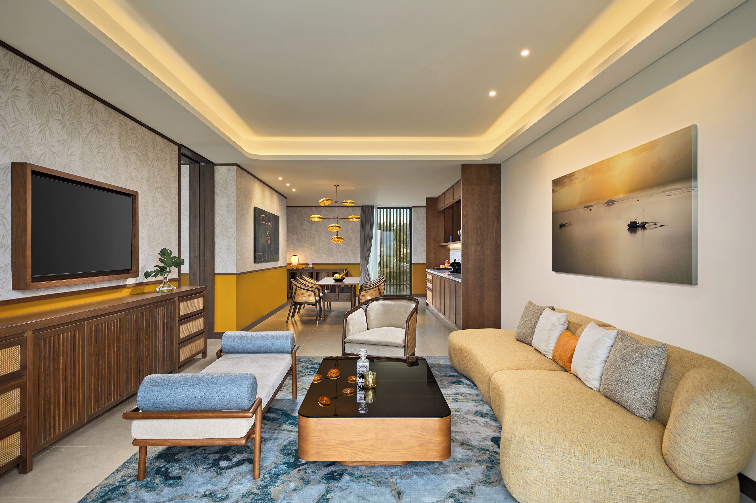 Un salon moderne doté d’un téléviseur à écran plat, d’un canapé, d’une table basse et d’un coin repas avec des chaises et une table.