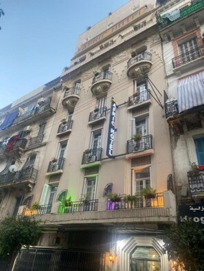 Un immeuble à plusieurs étages, sur lequel on peut voir une grande enseigne indiquant « AFRIC HOTEL ».