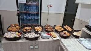 Un área de bufé con diferentes opciones de comida y un refrigerador lleno de bebidas.