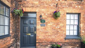 A brick building with a black door, a window, and a sign indicating "21 House". - Hampshire Charming House (Lincoln)
