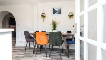 A dining area with a table, chairs, and a potted plant.