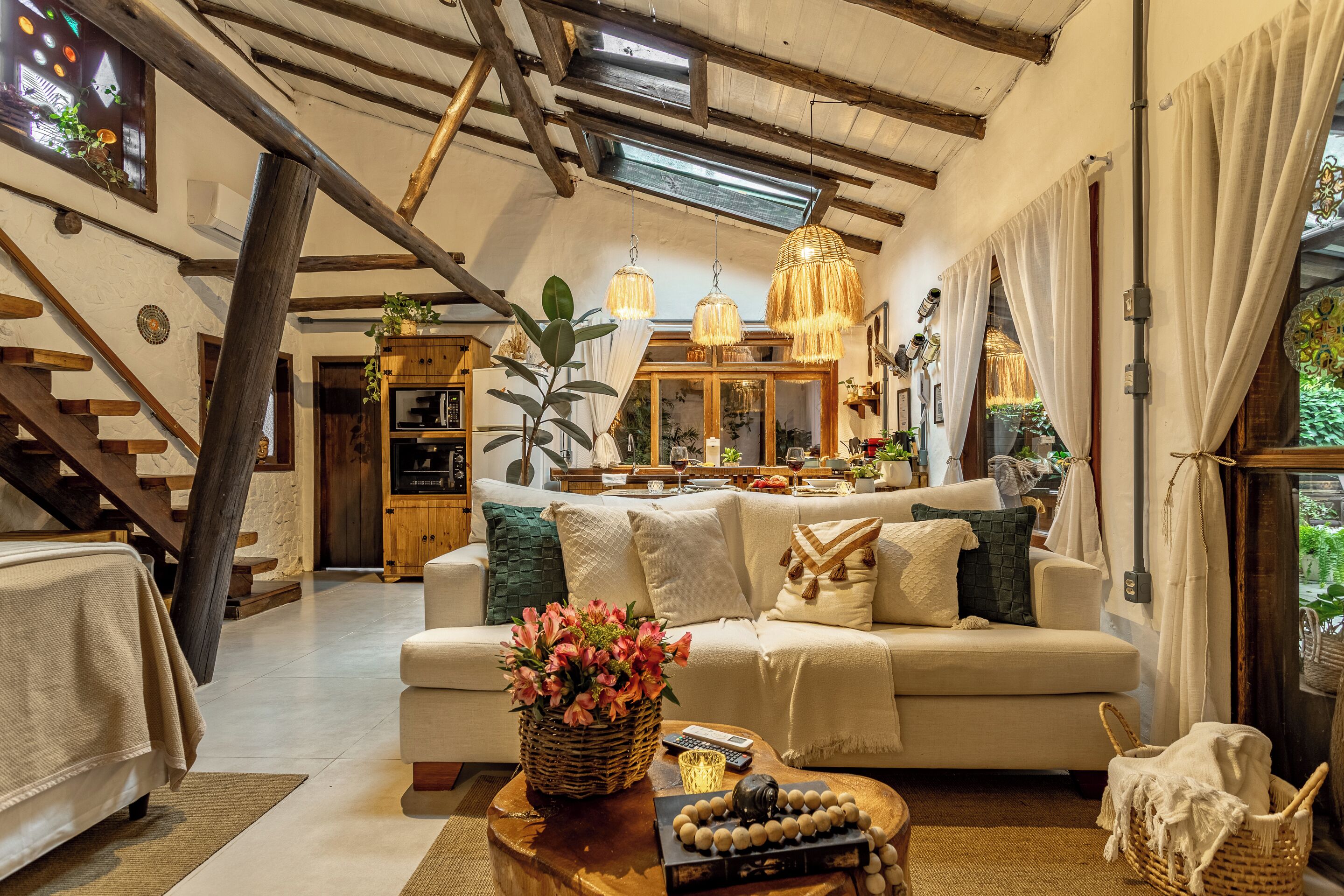 A cozy living room with a sofa, a coffee table with a vase of flowers, and a wooden cabinet.