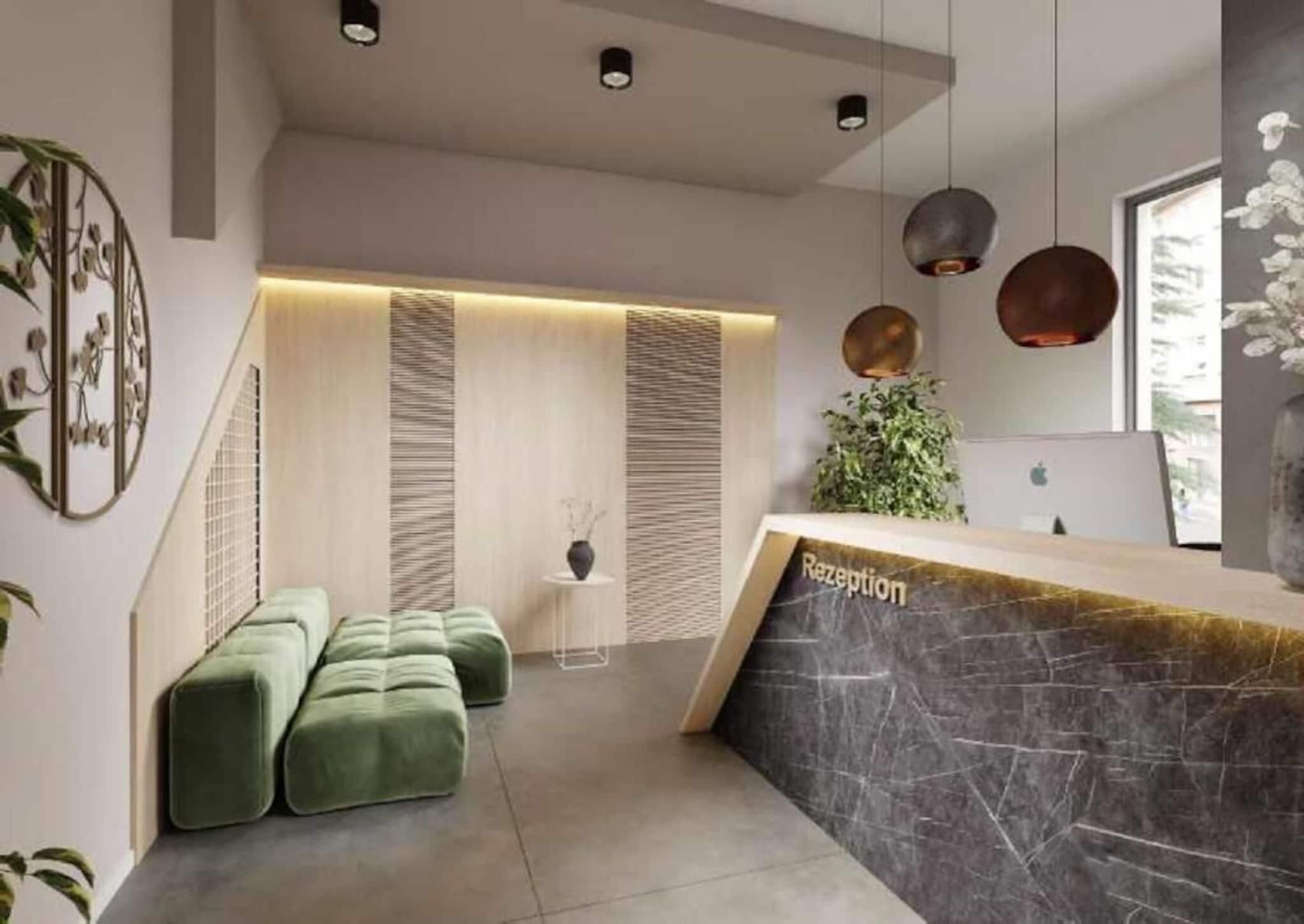 Una moderna zona de recepción con mostrador de mármol, asientos verdes y una planta.