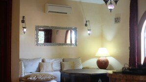 Quarto de hotel com cama, cómoda, espelho e candeeiro.