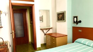 A bedroom with a bed, a dresser, a mirror, and a door leading to another room. - Ca du Paraxo (Levanto)