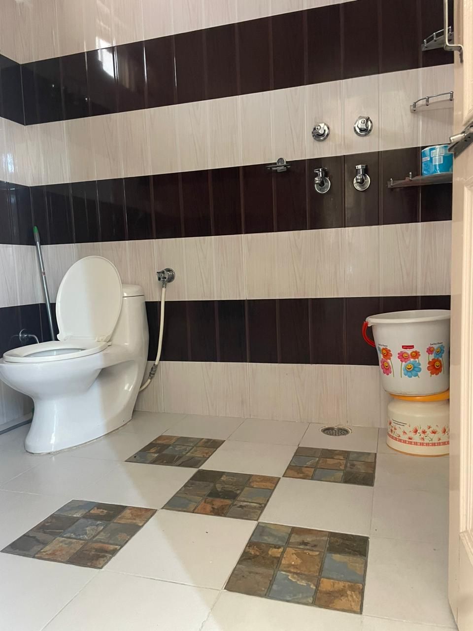 A bathroom with a toilet, a bidet, and a decorative ceramic container.