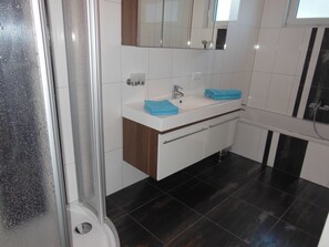 Een douche, een haardroger, handdoeken, toiletpapier