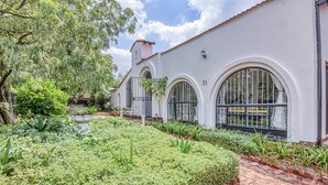 A white building with arched windows and a brick pathway.