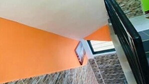 A staircase with a stone wall and orange flooring leading to a higher level. - Studio Avec Vue sur Jardin (Mpolongwé)