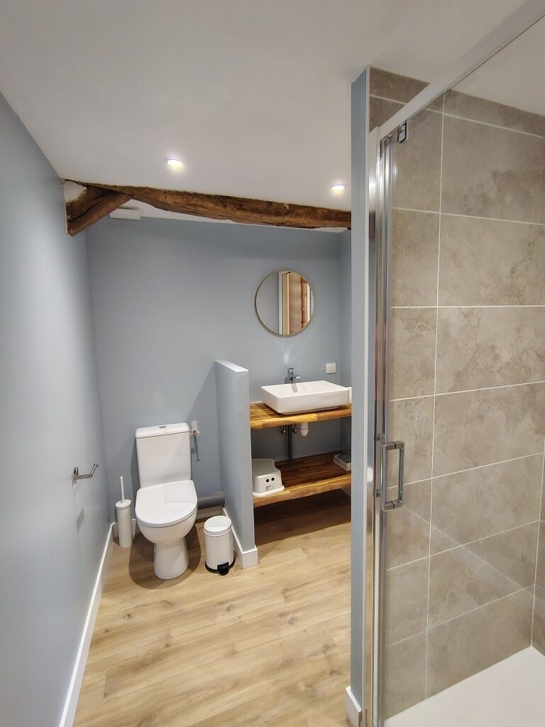 Et badeværelse med toilet, vask og bruseniche.