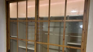 A room with a wooden-framed sliding glass door leading to a closet with multiple shelves. - PearlDaisy Butuan Transient Home Philippines (Butuan City)