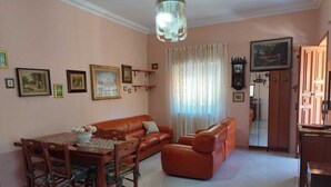 Una sala de estar con mesa de comedor, sofá de cuero y candelabro.
