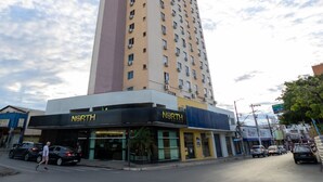 Un hotel alto con diversi piani, una facciata lineare e un cartello con la scritta 'NORTH HOTEL' al piano terra.