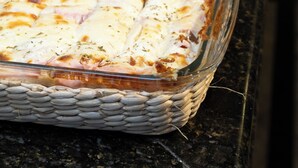 Un buffet con diversi piatti, tra cui pane a fette e un sformato.
