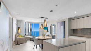 A modern kitchen with a central island, pendant lighting, and a view of the sea. - Endless Views | Oceanfront Balcony | Hot Tub (Hollywood)