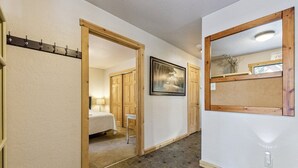 A hallway with a bed, a mirror, and a picture on the wall. - 750 Stanford Avenue 3 Bedroom Cabin by RedAwning (South Lake Tahoe)