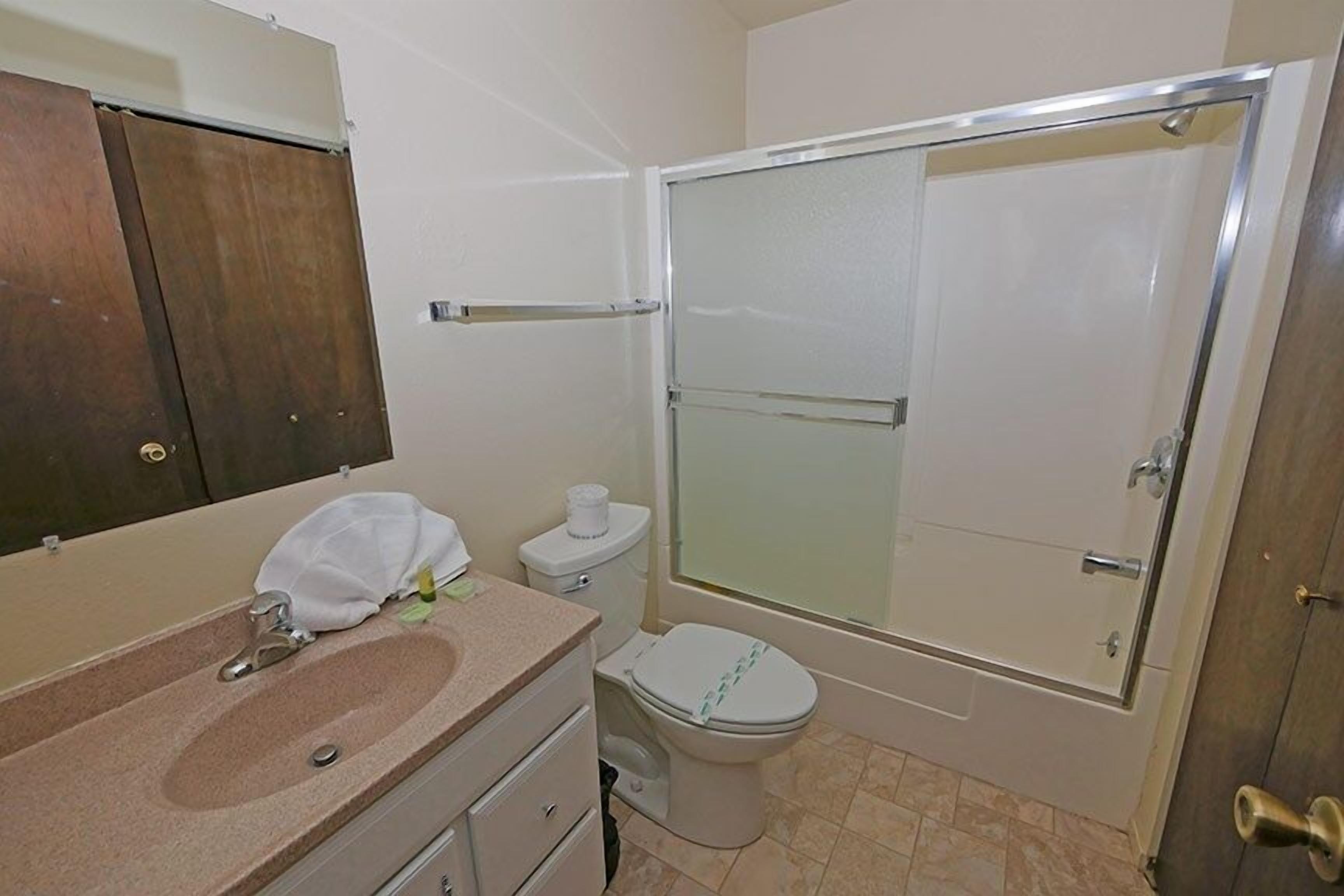 A bathroom with a sink, toilet, and shower.
