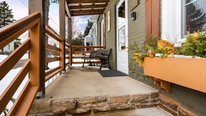 A covered porch with stone steps, wooden railings, and a bench. - Pinecone Haven - Where Northwoods meets the Southwest  (Sturgeon Bay)