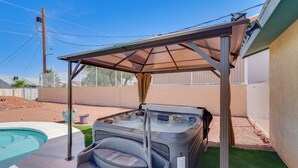 A hot tub under a shaded area with a pool nearby. - Cozy Lake Havasu City Home - Pool and Hot Tub (Lake Havasu City)