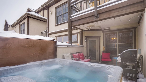 A hot tub in a snowy outdoor area with a wooden deck and a barbecue grill. - Walk to Ski Lift: Breck Condo w/ Hot Tub (Breckenridge)