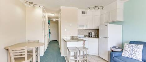 A compact living space with a kitchenette, a dining area, and a seating area.