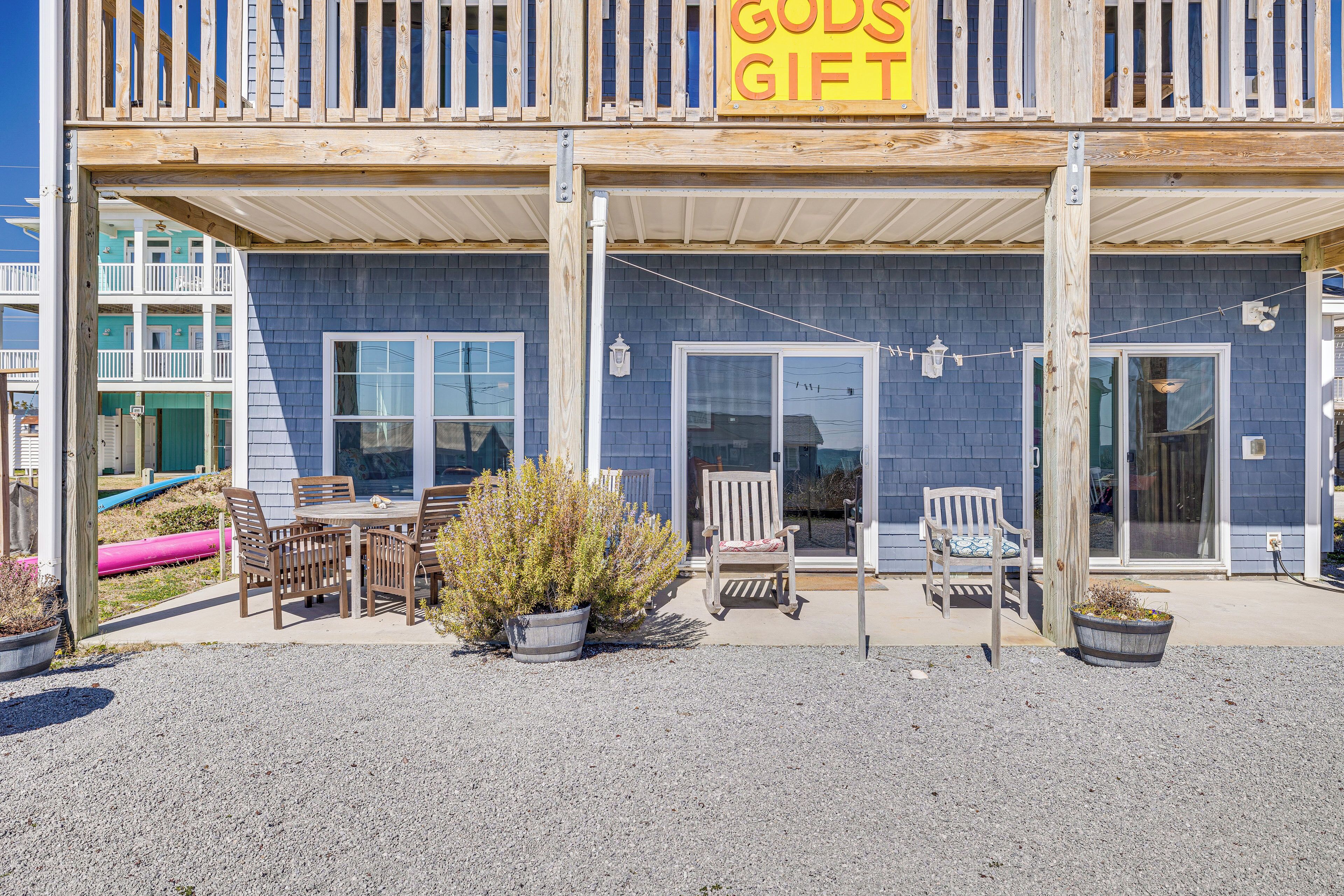 A building with a sign reading "GODS GIFT" and a covered patio area with outdoor seating.