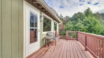 A wooden deck with a railing, a chair, and a table.