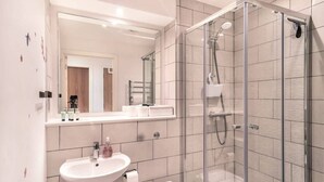 A modern bathroom with a glass-enclosed shower, a sink, and a toilet. - Stunning Modern 1 Bed Apartment, Manchester (Salford)