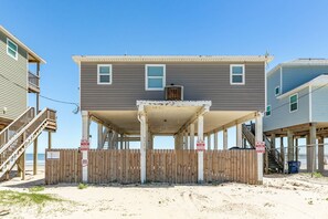 Une maison à deux étages avec un porche couvert et une clôture en bois.
