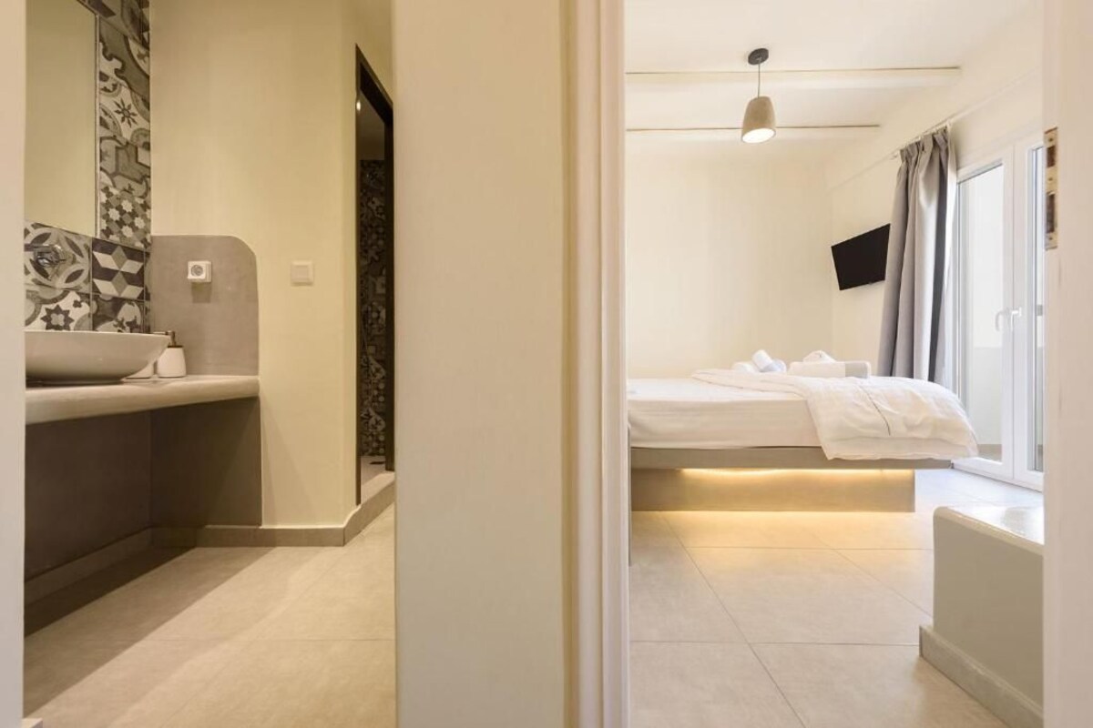 A modern bathroom with a sink, mirror, and patterned tiles.