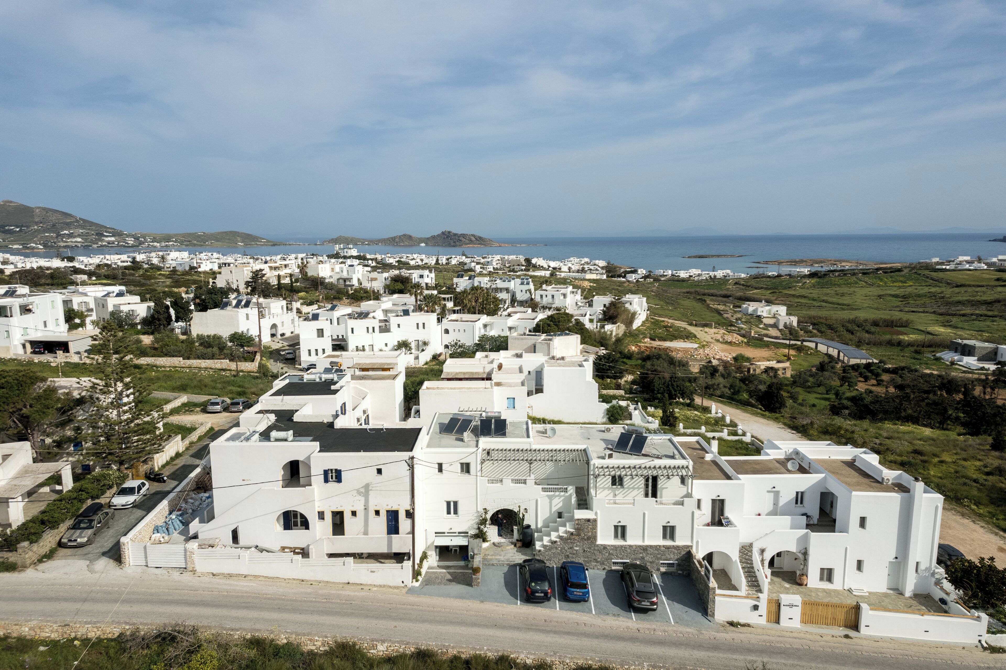 A coastal town with white buildings, a clear sky, and a view of the sea.