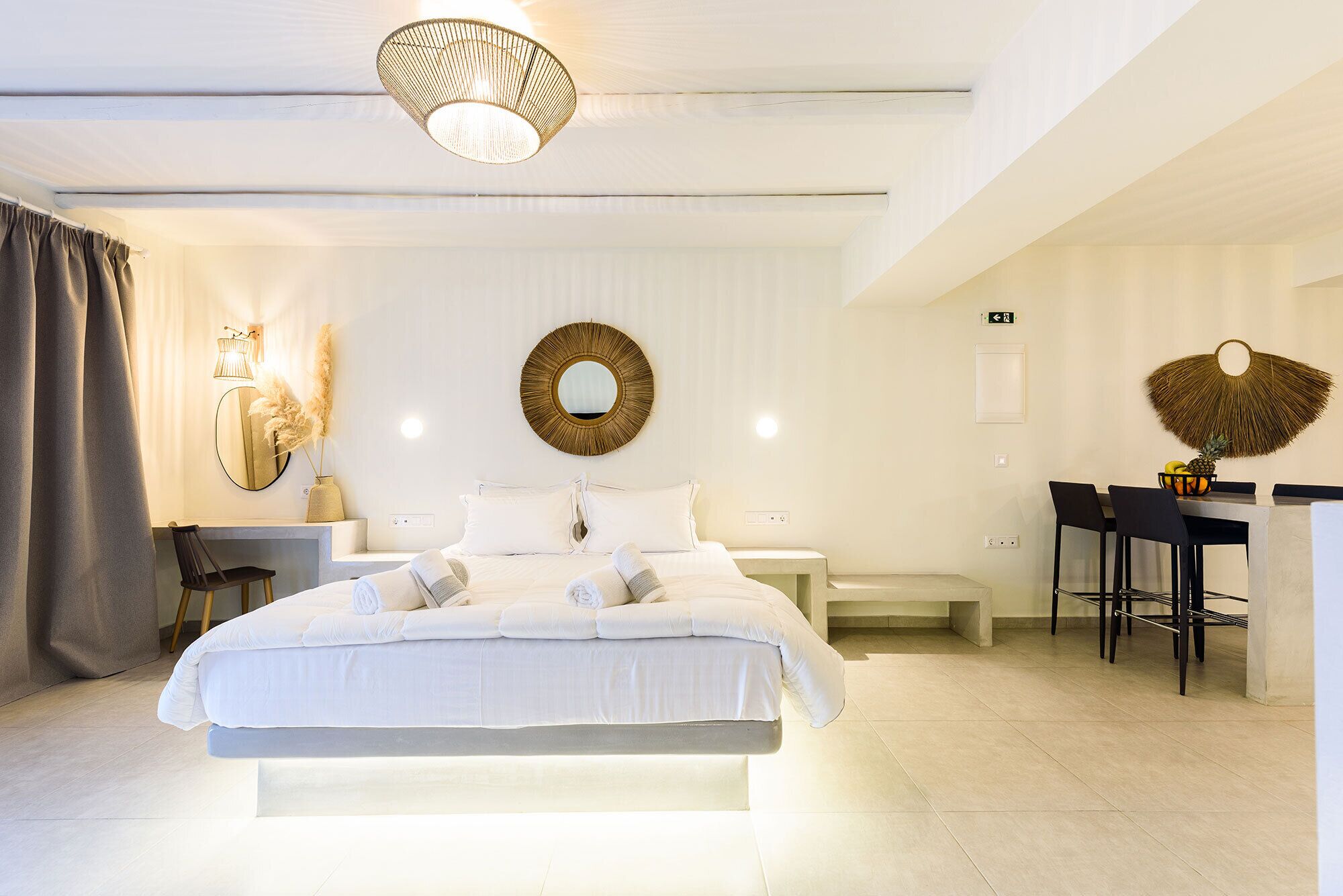 Une chambre d’hôtel moderne, dotée d’un grand lit, d’un bureau et d’un coin repas.