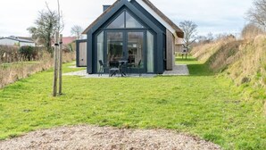 Una casa moderna con un amplio ventanal y techo de paja.