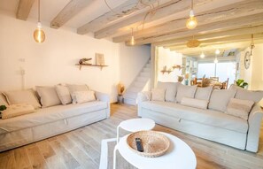 Un salon avec deux canapés, une table basse et un escalier menant à une autre pièce.